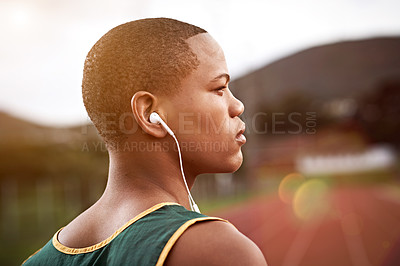 Buy stock photo Cropped shot of a young athlete listening to music while out on the track