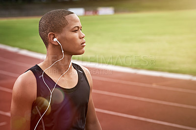 Buy stock photo Cropped shot of a young athlete listening to music while out on the track