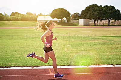 Buy stock photo Shot of a young athlete out running on the track
