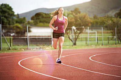 Buy stock photo Shot of a young athlete out running on the track