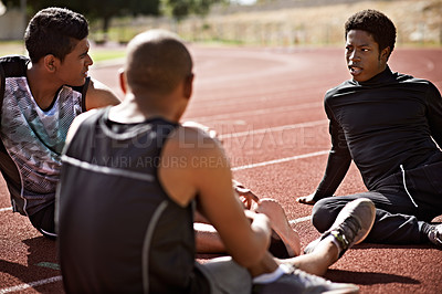 Buy stock photo Shot of young athletes sitting together on the track
