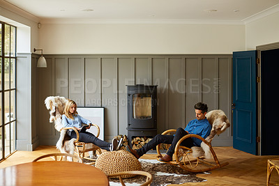 Buy stock photo Shot of a couple using digital tablets while relaxing on rocking chairs at home