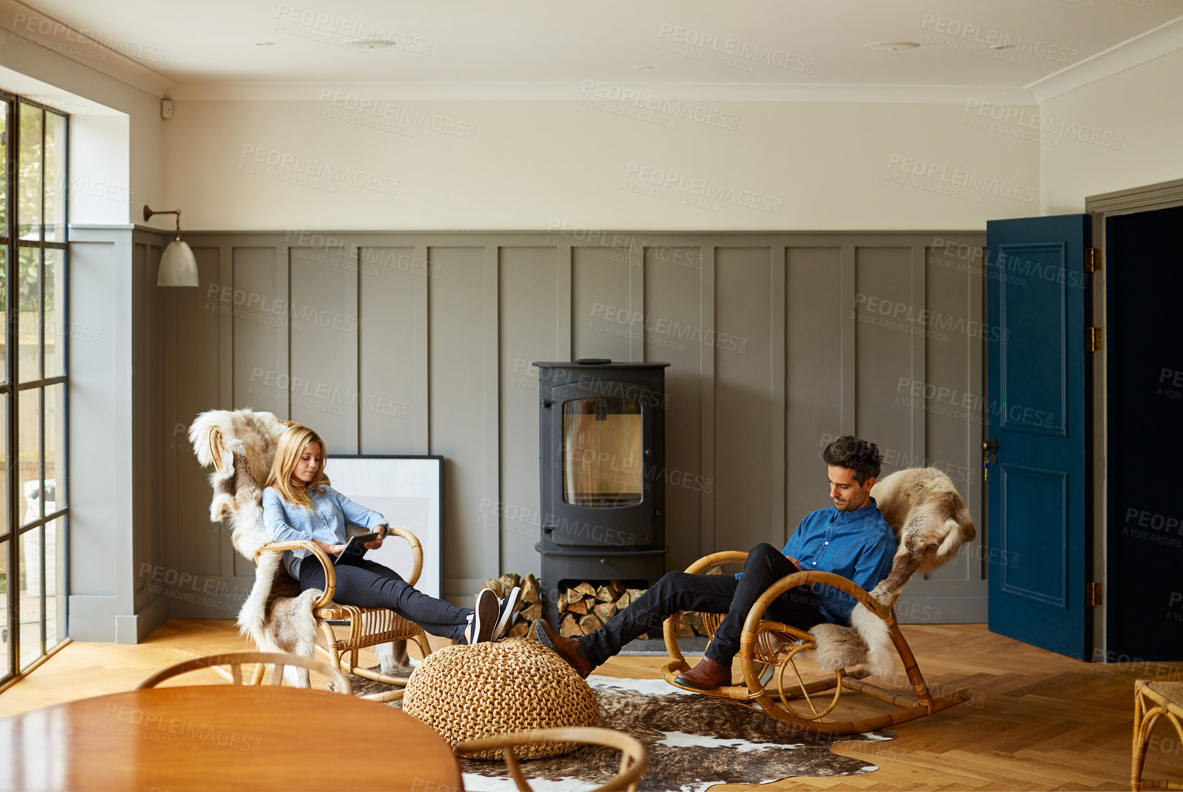Buy stock photo Shot of a couple using digital tablets while relaxing on rocking chairs at home