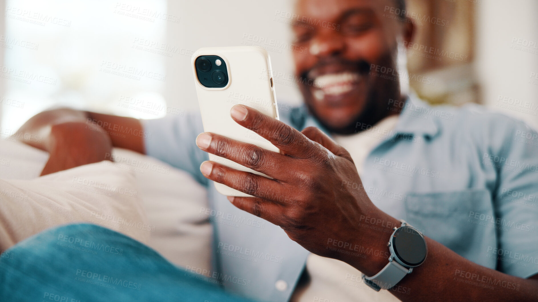 Buy stock photo Browsing, hand and black man in house with phone, online communication and comic post on social media. Laugh, digital and person on couch with tech, funny message or meme reaction on chat app.