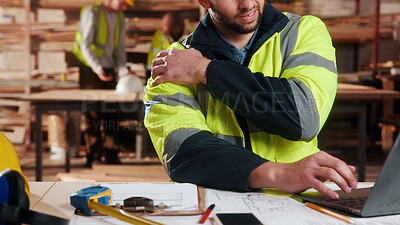 Buy stock photo Carpenter, hands and shoulder pain in workshop with laptop, fatigue or burnout in industry. Project planning, tech or man in woodworking factory with joint injury, physical strain or muscle stiffness