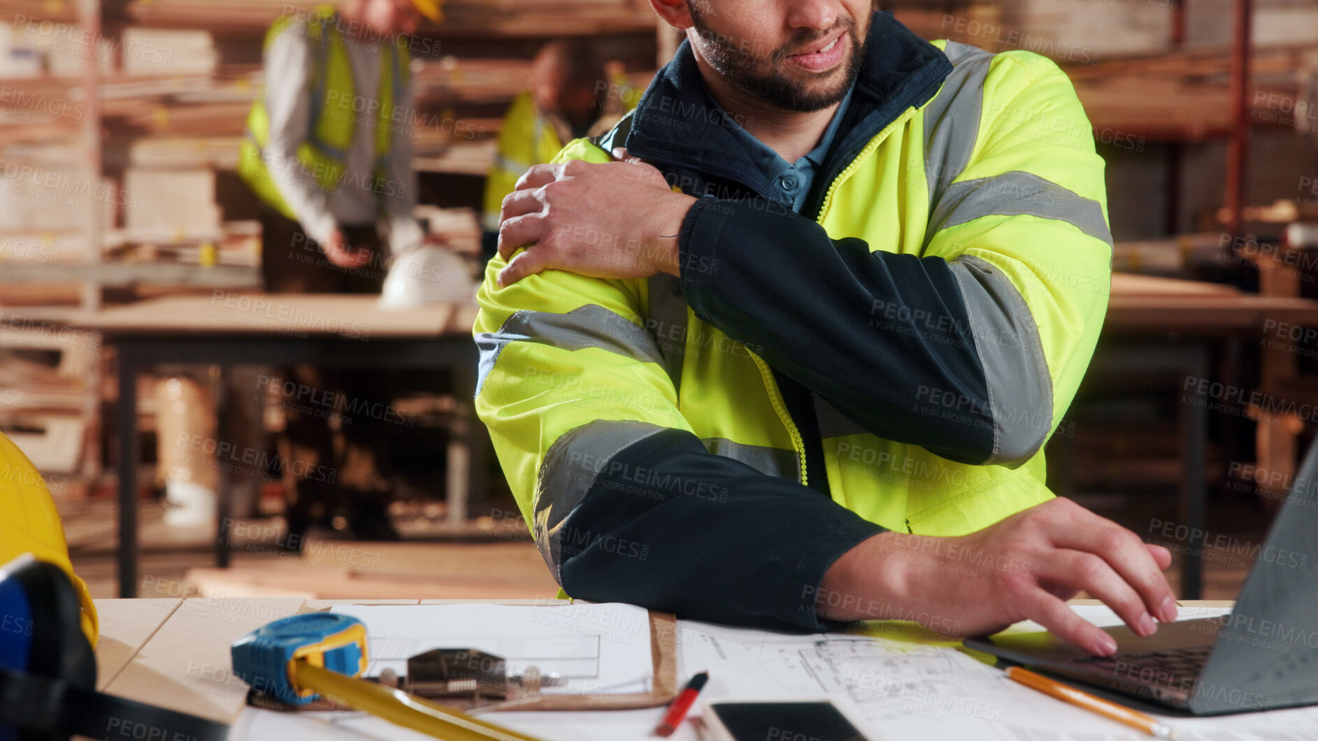 Buy stock photo Carpenter, hands and shoulder pain in workshop with laptop, fatigue or burnout in industry. Project planning, tech or man in woodworking factory with joint injury, physical strain or muscle stiffness