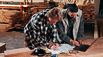 Men, laptop and documents in lumber workshop, carpenter and team with invoice, writing and woodwork. Conversation, collaboration and people with tech, notes and online order with carpentry planning