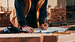 Person, hands and carpenter writing with documents in warehouse for wood stock or lumber production. Carpentry, artisan or schedule with paperwork for furniture distribution or inventory in workshop