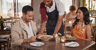 Buy stock photo Waiter, serving and couple in restaurant for date, connection or bonding on weekend together. Happy, food and server with man and woman for dinner, meal or supper order on anniversary in diner.