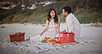 Love, celebration or couple at beach with picnic, holiday together or bonding on romantic anniversary. Happy, honeymoon or people with fruit, partner connection or special moment on outdoor getaway.