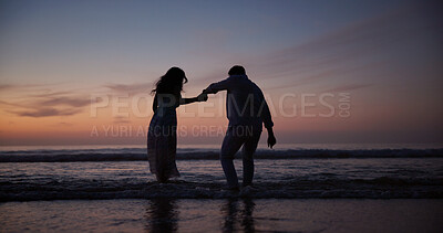 Buy stock photo Couple, walking and holding hands at beach with silhouette, travel and romantic date on holiday. Back, sunset and people at seashore with space, commitment and tropical vacation for adventure getaway