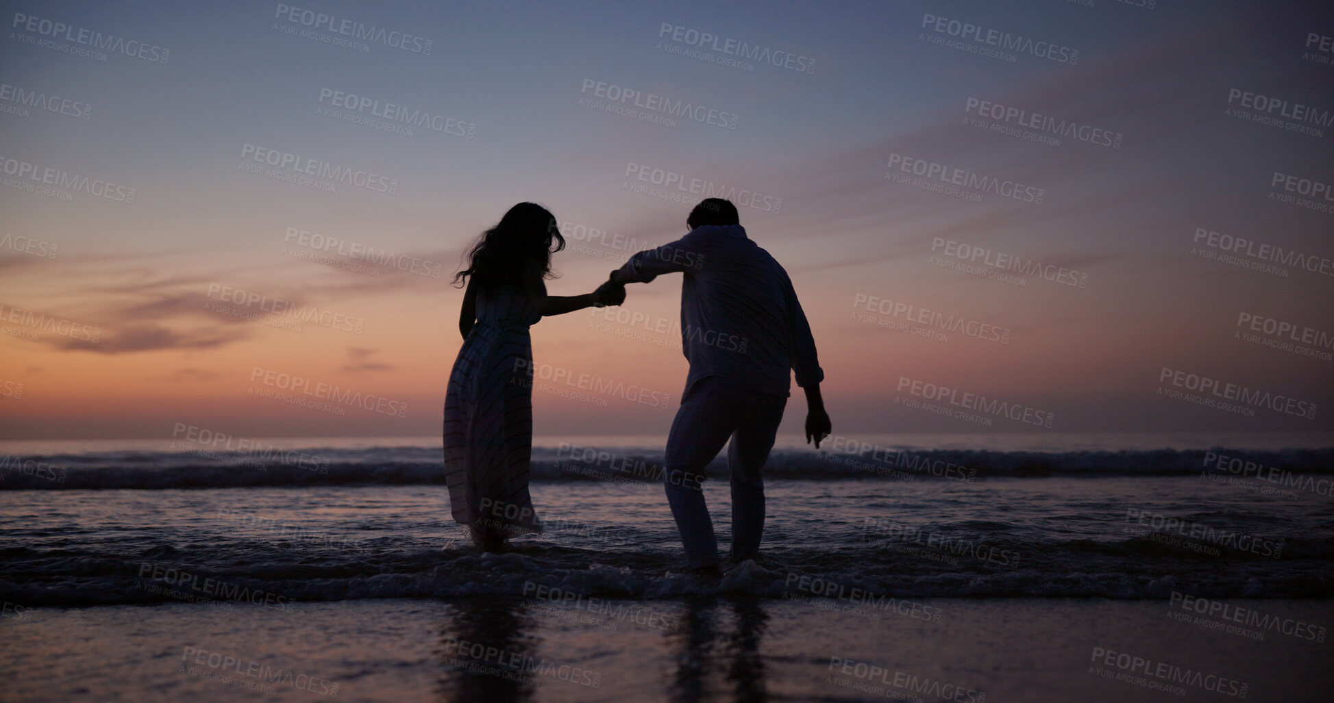 Buy stock photo Couple, walking and holding hands at beach with silhouette, travel and romantic date on holiday. Back, sunset and people at seashore with space, commitment and tropical vacation for adventure getaway
