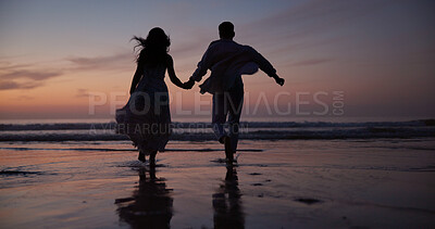 Buy stock photo Couple, running and holding hands at beach with silhouette, travel and romantic date on holiday. Back, sunset and people at seashore with partner, celebration and tropical vacation for adventure trip