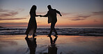 Couple, walking and holding hands at beach for travel, journey and romantic date on holiday. Silhouette, sunset or people at seashore with space, connection or tropical vacation for adventure getaway