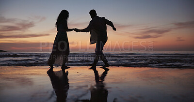 Buy stock photo Couple, walking and holding hands at beach for travel, journey and romantic date on holiday. Silhouette, sunset or people at seashore with space, connection or tropical vacation for adventure getaway