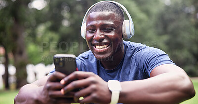 Buy stock photo Fitness, headphones and man with phone, laughing and texting with smile on social media app at park. Happy, athlete and black person with mobile for workout update, message and listening to music