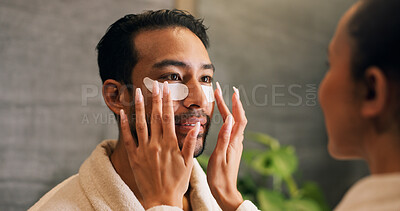 Buy stock photo Couple, skincare and eye mask application in bathroom for self care, dermatology or reduce dark circles. People, dating and apply collagen patch in home for clear skin, cosmetics or bonding together.