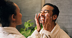 Couple, skincare and face cream application in bathroom with smile, dermatology or hydration benefits. Happy people, dating and apply moisturizer in home for clear skin, cosmetics or bonding together