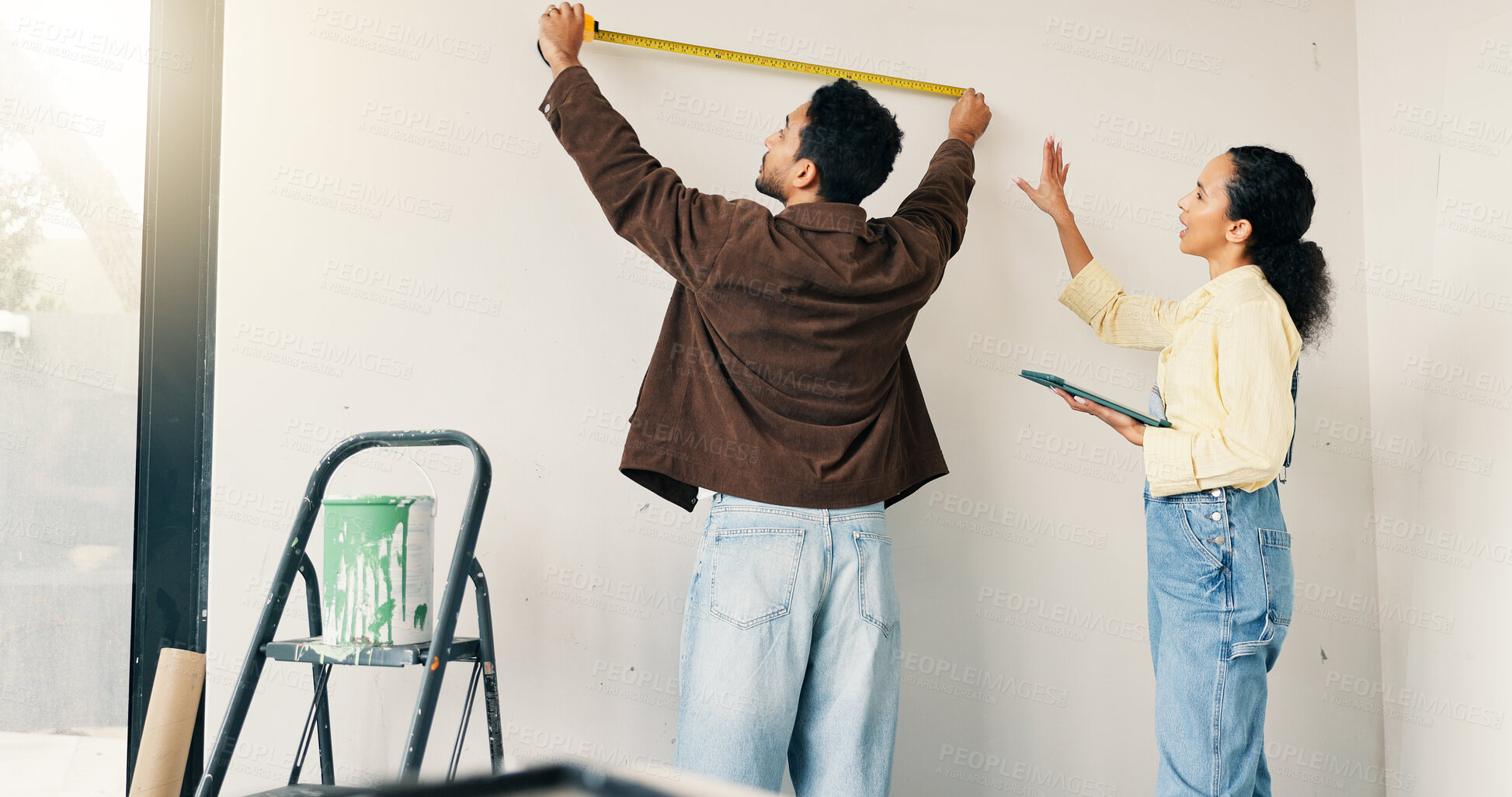 Buy stock photo Measuring, tool and couple in new home for renovation, maintenance or property development. Tape, real estate and man with woman for precision on wall for construction repairs in apartment together.