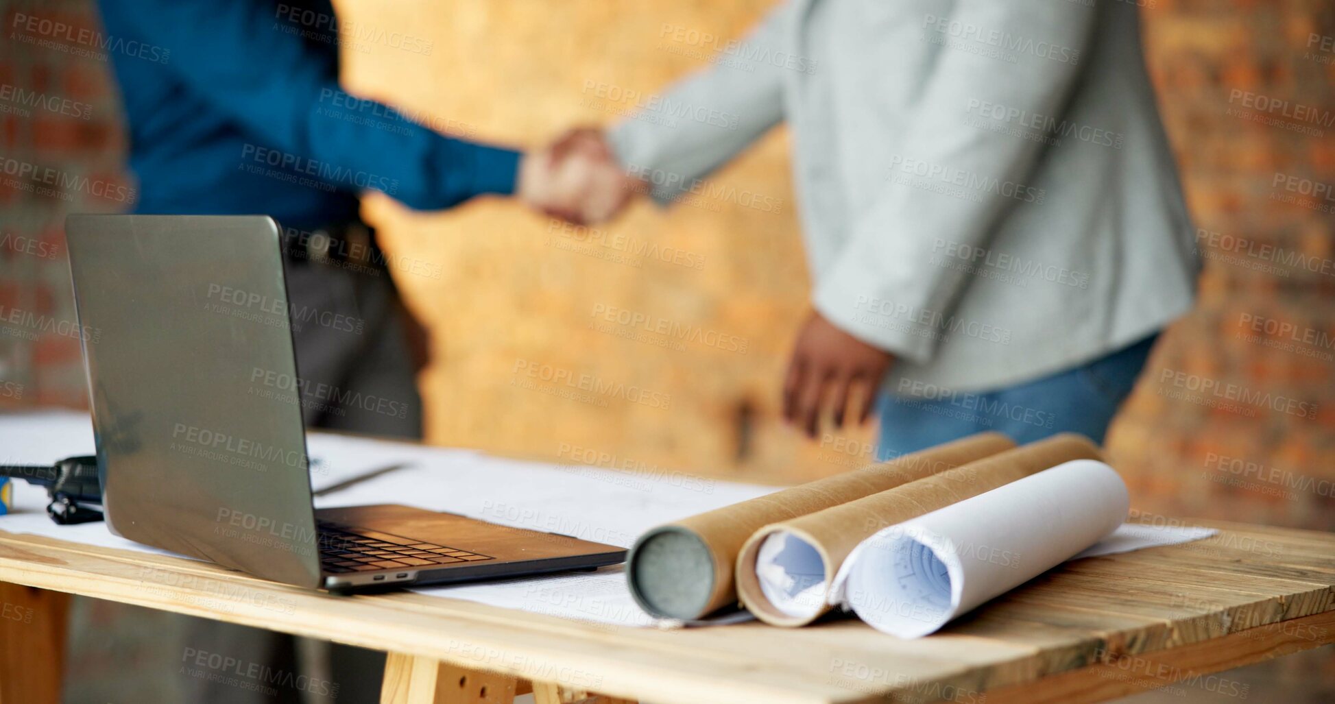Buy stock photo Construction site, laptop and blueprint on table, architecture or shaking hands for renovation plans. Civil engineering, people and tech for property development, handshake and paperwork with design