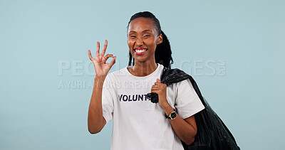 Buy stock photo Volunteer, portrait and black woman with okay sign, smile and trash or cleaning garbage in studio. Non profit, community service and space for motivation, success and plastic bag on blue background