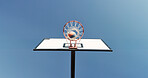 Outdoor, low angle and basketball hoop on empty court for game, training or workout with competition. Blue sky, nature and sports equipment with net for match, practice or exercise with challenge.