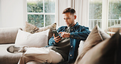 Buy stock photo Cellphone, relax and man on sofa in home with texting, chatting or social media on mobile app. Tech, chilling and person on phone for reading online blog for tips or advice in living room at house.