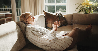 Buy stock photo Typing, sofa and senior woman with phone, social media and message for internet connection. Retirement, home and person on cellphone for contact, digital puzzle and website search in living room