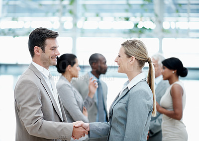 Buy stock photo Corporate, lobby and business people with handshake in office for agreement, merger and b2b deal. Team, professional and man with woman shaking hands for financial partnership, welcome and thank you