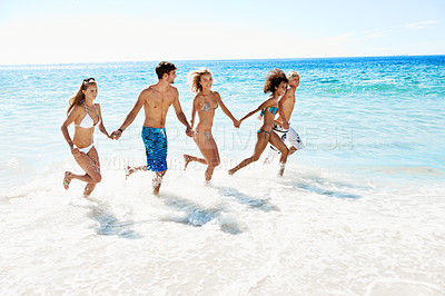 Buy stock photo Holding hands, running and summer with friends at beach for vacation, support and travel. Tropical getaway, connection and adventure with group of people in ocean for tourism, holiday and bonding