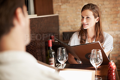 Buy stock photo Woman, couple and discussion in restaurant with menu, meal decision and bonding on weekend break. Happy people, romantic relationship and talk with dining choice, wine list and opinion for cuisine.