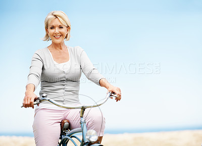 Buy stock photo Sky, portrait and happy woman on bicycle, cycling or adventure with eco friendly transport in nature. Outdoor, mockup space and mature person with smile, travel and bike with zero carbon emissions
