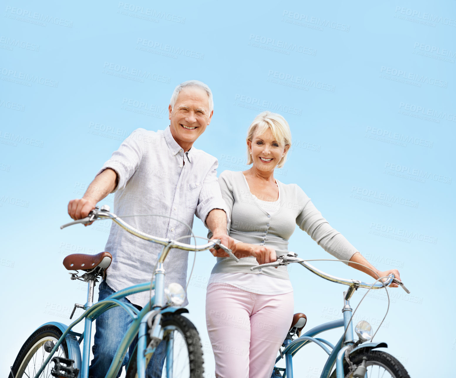 Buy stock photo Smile, portrait and senior couple on bicycle outdoor on vacation, getaway or weekend trip together. Space, blue sky and elderly man with woman on bike for cycling, bonding or adventure on holiday.