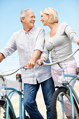 Buy stock photo Love, cycling and smile with old couple in nature for bonding, weekend break and anniversary vacation. Retirement, holiday and travel with senior man and woman on bicycle outdoor for marriage
