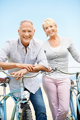 Buy stock photo Outdoor, bicycle and portrait with elderly couple, travel or transportation with partner on vacation. Happy man, woman and bike at beach for cycling, love or active retirement for health on holiday