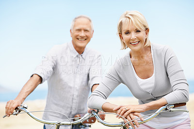 Buy stock photo Beach, bicycle and travel with senior couple, portrait or fitness with partner on vacation. Happy man, woman and bike outdoor for cycling, exercise and active retirement for wellness on holiday