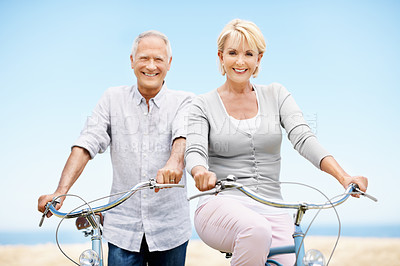 Buy stock photo Love, portrait and senior couple on bicycle outdoor on vacation, getaway or weekend trip together. Smile, blue sky and elderly man with woman on bike for cycling, bonding or adventure on holiday.
