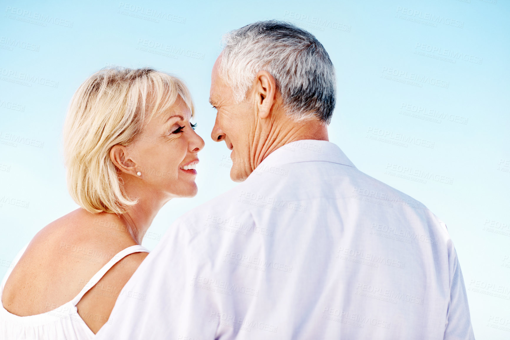 Buy stock photo Happy, space and couple outdoor on holiday, getaway or weekend trip together for bonding. Smile, love and mature woman with man by blue sky for connection, commitment or care in marriage on vacation.