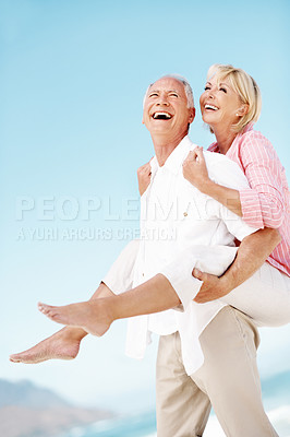 Buy stock photo Holiday, laugh or elderly couple at beach with piggyback, bonding or happy moment on trip. Love, space or senior people with fun, romantic relationship or playful connection on outdoor getaway.