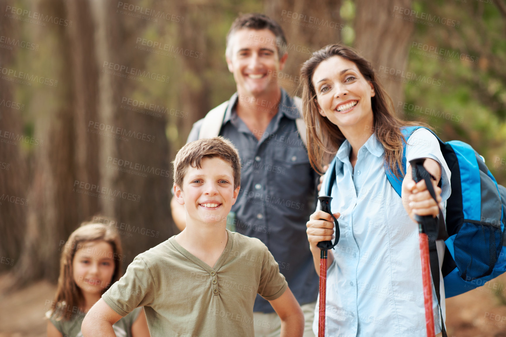Buy stock photo Hiking, nature and portrait of family outdoor for adventure, exploring or bonding on holiday. Happy, support and parents with children in forest for trekking on vacation, getaway or weekend trip.
