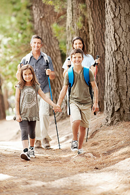 Buy stock photo Hiking, holding hands and portrait of family outdoor for adventure, exploring or bonding on holiday. Happy, travel and parents with kids in forest for trekking on vacation, getaway or weekend trip.