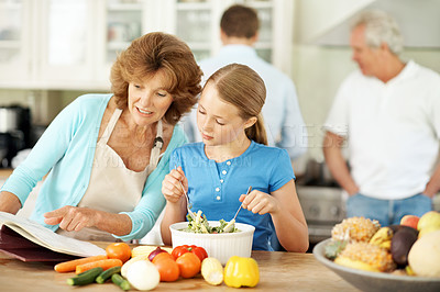 Buy stock photo Reading, recipe and grandma with child, cooking and learning culinary skills in kitchen or pointing. Happy, senior woman and meal prep with girl, family connection and discussion with kid in house