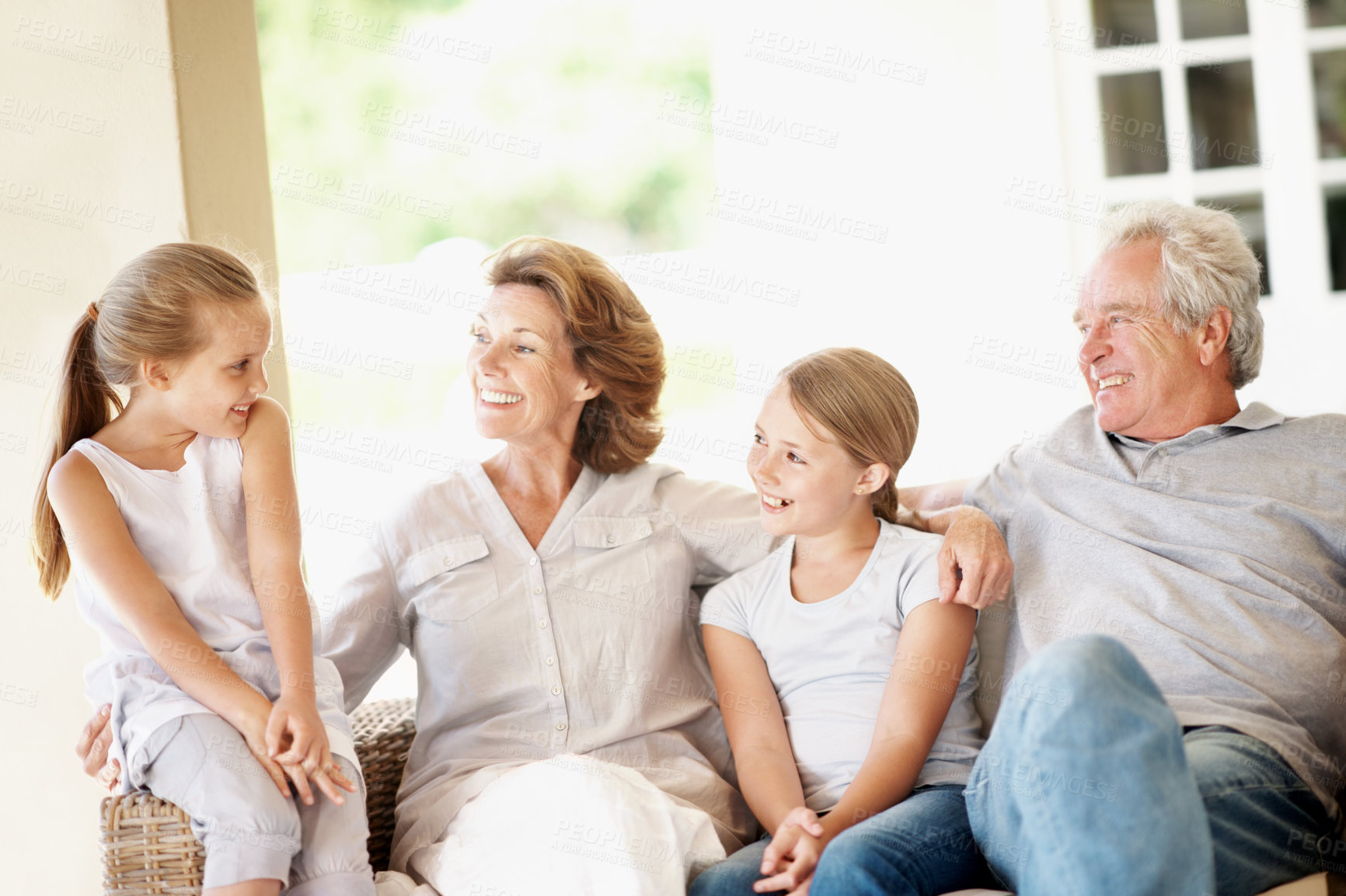 Buy stock photo Happy, grandparents and kids with talk on porch for love, holiday visit or relationship development. Hug, senior people and grandkids with chat at home for weekend break, family bonding and support