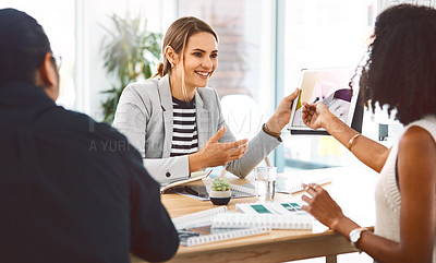 Buy stock photo Shot of young businesspeople using a digital tablet during a meeting in a modern office