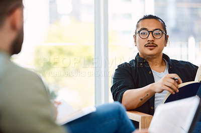 Buy stock photo Shot of two young businessmen having a meeting in a modern office
