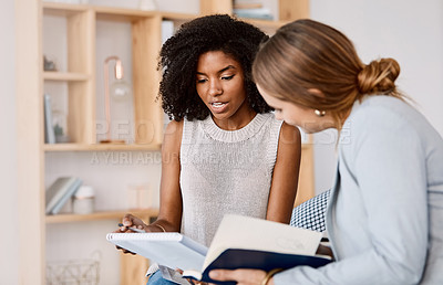 Buy stock photo Shot of two young businesswomen having a discussion in a modern office