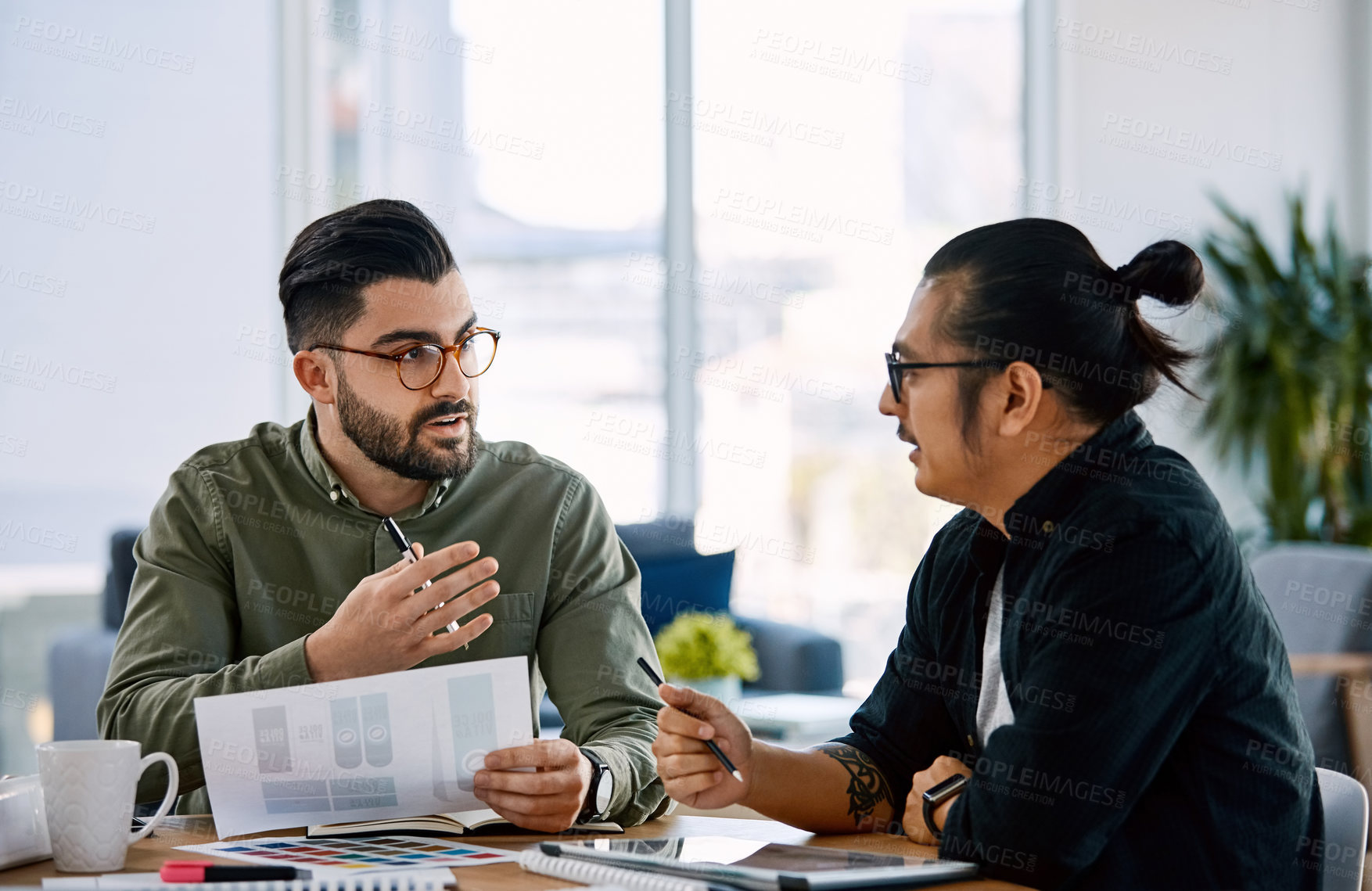 Buy stock photo Shot of two young businessmen having a meeting in a modern office