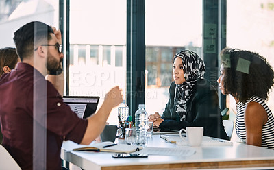 Buy stock photo Shot a group of young businesspeople planning and having a discussion during a meeting at work