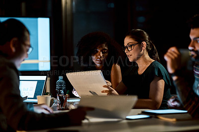 Buy stock photo Shot of a group of young businesspeople having a late night meeting at work