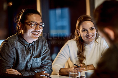 Buy stock photo Shot of a group of young businesspeople having a late night meeting at work